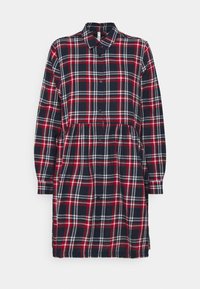 Abito in flanella a quadri rosso, blu navy e bianco con patta a bottoni, colletto, maniche lunghe e vita arricciata per maggiore volume.