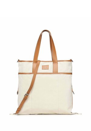 Cremefarbene Tote-Tasche mit braunen Ledergriffen und Besatz, mit verstellbarem Schulterriemen und vorderem Patch-Detail.