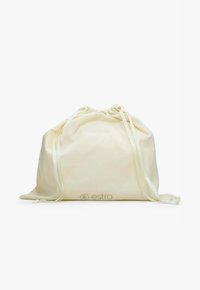 Šňůrkový sáček z lehké krémové látky s hladkou strukturou; má dvě saténové stužky a vytištěné logo na přední straně.