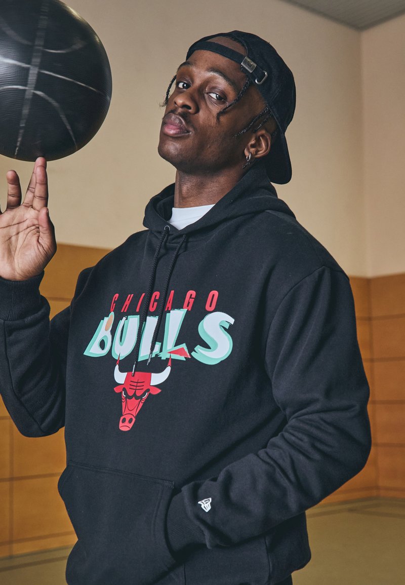 Felpa nera con grafica "Chicago Bulls" in rosso e turchese, con logo di un toro rosso. Tessuto di cotone liscio e tasca a marsupio.