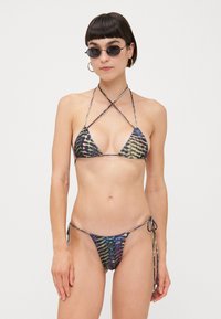 Bikini komplet z večbarvnim vzorcem praproti. Triangel natančni z prečnimi trakovi. Spodnji del z vezalkami ob strani. Gladka tekstura in minimalna pokritost.