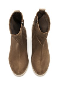 Botines de ante marrón con textura suave, cierre de cremallera y diseño de punta redondeada. Presenta una suela de goma beige contrastante.