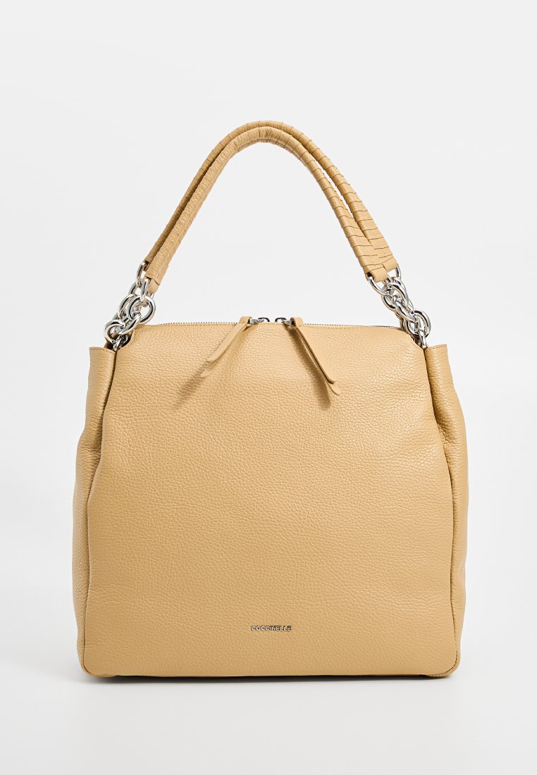 Bežs ādas rokassoma ar strukturētu formu, ar teksturētu rokturi, sudraba krāsas detaļām un rāvējslēdzēja aizdari.