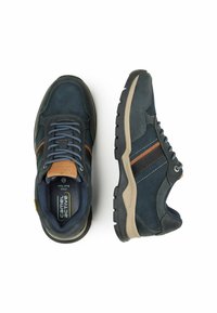 Ciemnoniebieskie zamszowe sneakersy z szarymi akcentami i brązowym paskiem. Posiadają teksturowaną podeszwę i wyściełany kołnierz dla komfortu. Widoczny logo.