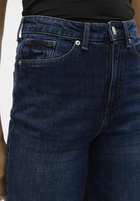 Mörkblå denimjeans med rak passform, som har framfickor, knäppning med knapp och synliga sömnadsdetaljer.