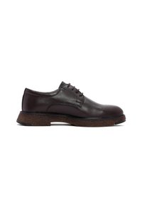 Chaussure habillée en cuir marron avec un bout rond, 5 œillets et une semelle en liège épaisse. Texture lisse avec des détails de coutures subtils.