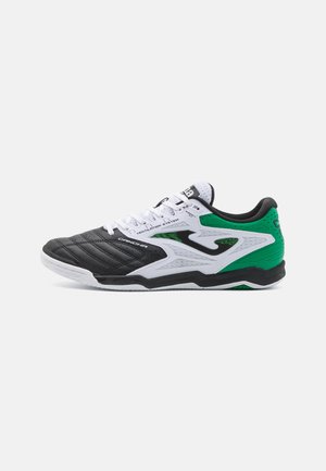 Zapatilla deportiva en blanco y negro con acentos verdes, que cuenta con una parte superior texturizada, cierre de cordones y detalles moldeados para soporte y ventilación.