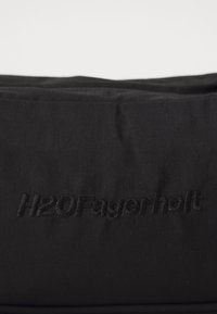 Borsa in tessuto nero con superficie texturizzata, con logo in rilievo "H2O Fagerholt". Design semplice con linee pulite, senza hardware o accenti visibili.