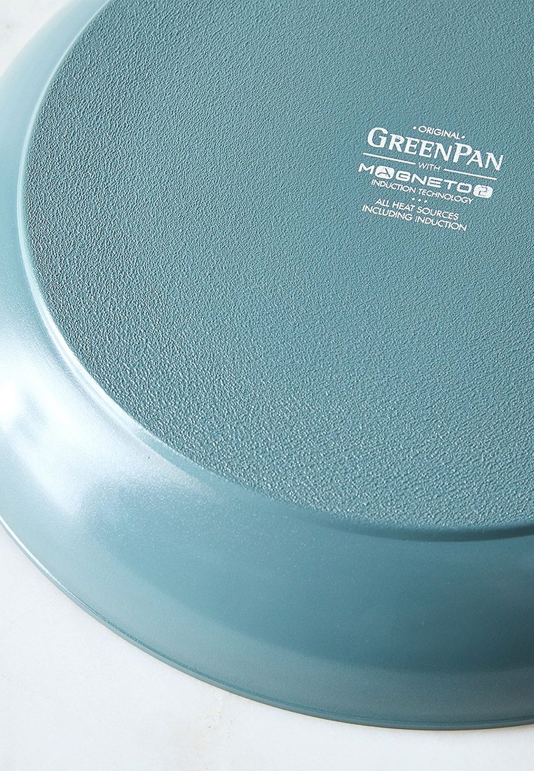 Base de sartén azul-verde mostrando la etiqueta "GreenPan con tecnología de inducción Magneto2" y superficie texturizada para compatibilidad con el calor.