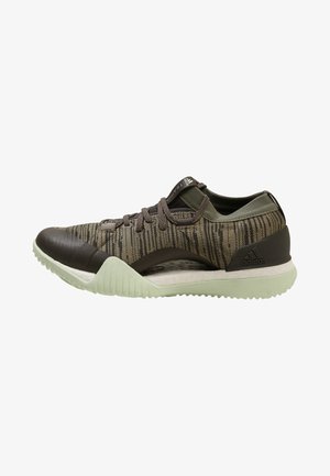 Des baskets noires et vertes avec une tige texturée, présentant un design à motifs, des lacets ronds et une semelle vert clair.