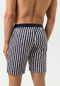 Marineblauwe boxershorts met verticale strepen, voorzien van herhaalde illustraties van een figuur. Zachte stof, elastische tailleband en mid-length snit.