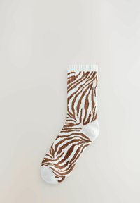 Bijela čarapa s smešastim uzorkom zebra, rebrasti rub i glatka tekstura. Standardne dužine, dizajnirana za udobnost i stil.
