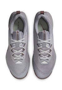 Nike trail shoes in light grey mesh with brown accents. Features white laces and supportive collar. Textured rubber outsole.