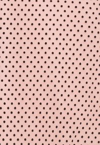 Světle růžová látka s vzorem rovnoměrně rozmístěných černých teček. Textura vypadá hladce a jemně, s konzistentním designem po celé ploše.
