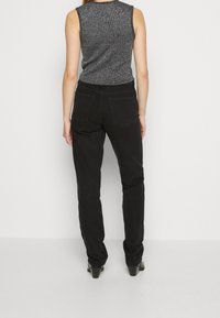 Sorte denim jeans med slim fit, femlomme-design og minimale syninger. Stoffet har en glat tekstur.