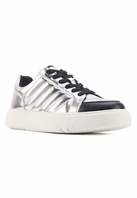 Silberne metallische Sneaker mit schwarzen Akzenten, die eine glatte Oberfläche, ein schnürbares Design und eine klobige weiße Sohle mit strukturiertem Profil aufweisen.