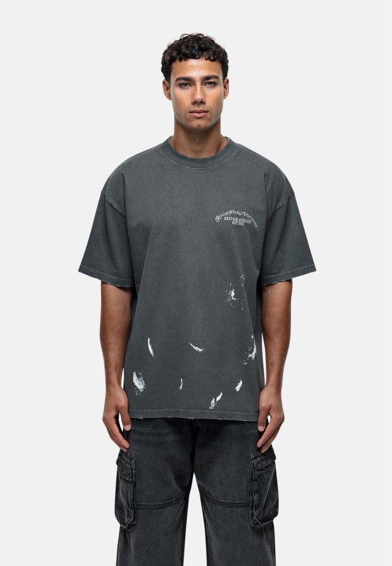 Overmaatse grijze katoenen t-shirt met versleten witte verfspetters, geribbelde ronde kraag, korte mouwen en logo-tekst in het wit boven de borst.