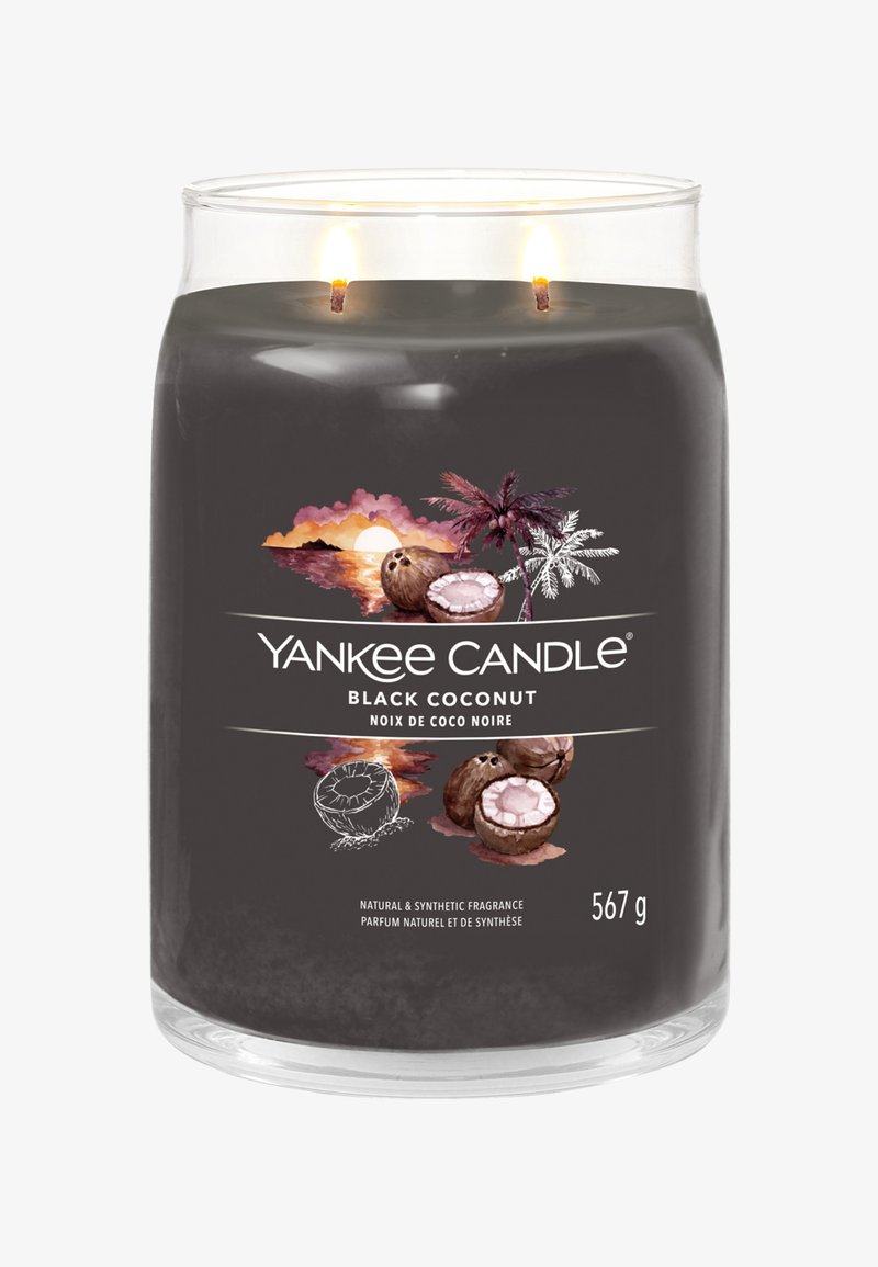 Bougie Yankee Candle parfumée à la noix de coco noire avec deux mèches allumées dans un pot en verre transparent, illustrée de dessins de noix de coco et de palmiers.