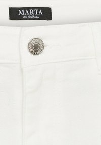 Hvide denimbukser med et waistband-tag, der læser "MARTA du château." Har en sølvknap og en subtil tekstur i stoffet.
