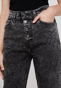 Svarta denim jeans med hög midja som har femknappslås, sidofickor och en sliten struktur med en urtvättad finish.