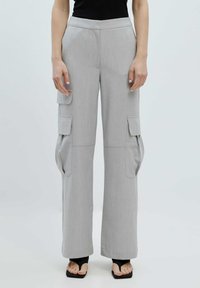 Grijze wijde cargobroek met twee zijzakken, een gladde textuur, hoge taille en persplooidetails. Draagt met zwarte schoenen.