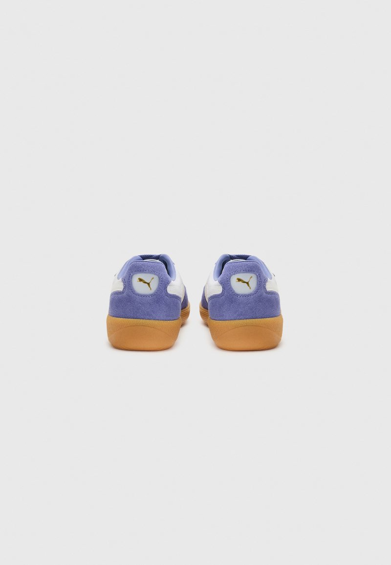 Sneaker in suede viola con accenti bianchi e suola in gomma, caratterizzati da un piccolo logo sul tallone. Design a profilo basso adatto per un uso casual.