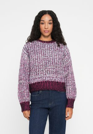Sweter robiony na drutach w kolorach fioletowym, różowym i białym o grubym splocie. Posiada okrągły dekolt oraz ściągacze przy mankietach i u dołu, z fasonem skróconym.
