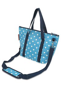 Bolsa tote azul con lunares blancos, asas reforzadas en navy, cierre con cremallera, correa desmontable y base plana para mayor estabilidad.