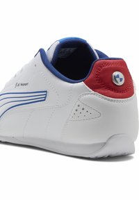 Hvid lædersneaker med blå og røde detaljer, der har en struktureret bag, perforeringer på siderne og et rundt logodetalje.