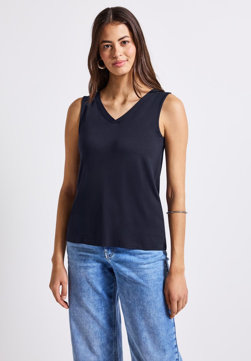 Marinblå ärmlös topp med V-hals, tillverkad av mjukt tyg. Skräddarsydd passform, slät textur och fållen sitter vid höftnivå. Inga mönster eller detaljer.