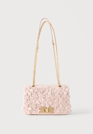 Petit sac à main rose pâle avec un motif floral en relief et une chaîne dorée pour la bandoulière et le fermoir.