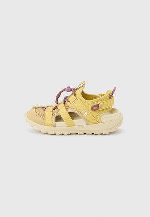 Yellow and beige outdoor sandal with purple adjustable drawstring laces, cushioned sole, and open toes and sides.