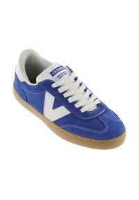 Sneakers en daim bleu avec accents blancs et lacets. Présente une semelle en caoutchouc et une tige texturée. Étiquette de la marque sur la languette.