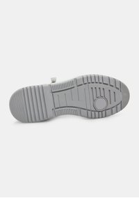 Šedá podrážka sneakers s vzorovaným gumovým dizajnom, obsahujúcim horizontálne a vertikálne drážky a kruhový akcent v blízkosti stredu.