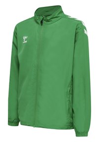 Grön lättviktsjacka med hög krage, dragkedja framtill och vita accentränder på axlarna. Tillverkad av ett slätt, vattenavvisande material.