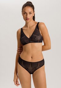 Black lingerie set featuring a triangular bralette and matching briefs. The fabric has a textured pattern with sheer sections and solid edges.