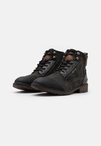 Stivaletti in suede nero con design a lacci, punta in pelle nera liscia a contrasto e dettagli in pelle marrone sul tallone e sul lato.