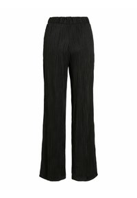 Pantalons large noirs avec une texture ondulée verticale subtile et une taille élastique, présentés sur un fond blanc uni.