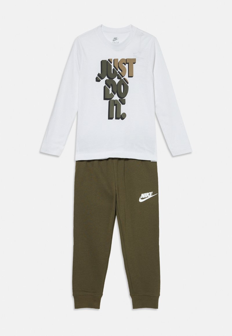 Chemise blanche à manches longues avec un graphique "JUST DO IT." en noir et olive ; pantalon de jogging olive avec le logo Nike blanc sur la jambe.