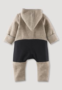 Romper con capucha en tonos marrón y negro hecho de tela suave, que presenta una parte superior texturizada, una parte inferior lisa y costuras en contraste a lo largo de los bordes.