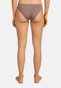 Slip bikini in cotone marrone con design a vita bassa, superficie liscia e fascia in cintura senza cuciture, fotografato da dietro.