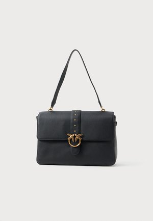 Bolsa de mão preta em couro com formato estruturado, apresentando um fecho frontal, metalizações em tom dourado, tachas decorativas e uma alça de mão superior.