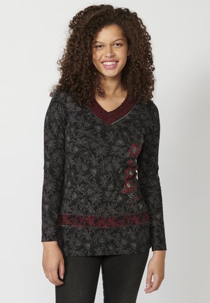 Haut noir à manches longues avec un motif floral, décolleté en V et accents brodés rouges au niveau du décolleté et de l'ourlet. Texture lisse.