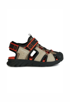 Sandalias resistentes al agua en beige y negro con acentos rojos. Cuentan con tiras ajustables, malla transpirable y suela de goma duradera.