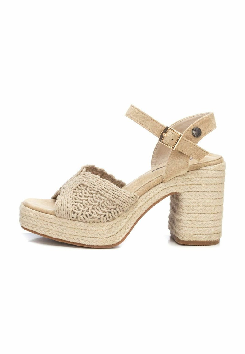 Sandalias de cuña beig con parte superior tejida texturizada. Cuenta con una abertura amplia para los dedos y una correa ajustable en el tobillo. Tacón de bloque envuelto en cuerda.