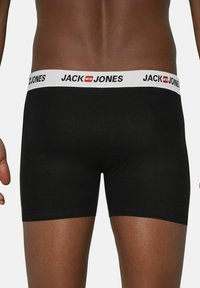Black boxer briefs with a white waistband displaying "JACK & JONES" logo. The fabric appears smooth with a fitted design.