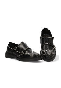 Zapatos de cuero negro con doble hebilla, acentos de tachuelas en la parte delantera y suela texturizada para mayor agarre. Diseño de corte bajo con puntera redondeada.