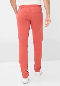 Pantaloni rossi con una vestibilità slim e un classico design a cinque tasche. Presentano tasche posteriori e una texture liscia, adatti per un abbigliamento casual.