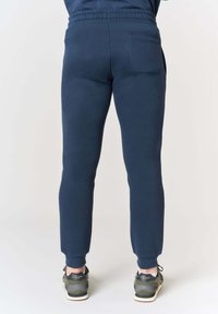 Pantaloni jogger blu navy con vestibilità affusolata, vita elastica e una tasca posteriore singola. Realizzati in materiale morbido e elasticizzato per il massimo comfort.