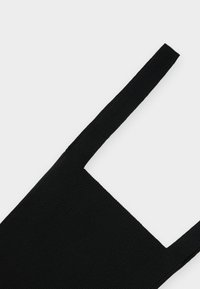 Top sem mangas de malha canelada preta com al�ças largas e decote quadrado sobre um fundo branco.